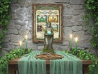 Wiccan altar with green goddess statur and a framed Earth Goddess poster, candles, and stones against a stone wall.