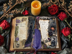 Open gothic-style vintage journal spread with spellbook-inspired pages, surrounded by red roses, dried flowers, and a lit candle for a moody Victorian look.