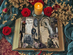 Open gothic-style vintage journal spread with spellbook-inspired pages, surrounded by red roses, dried flowers, and a lit candle for a moody Victorian look.