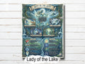 Framed artwork titled 'Lady of the Lake' on a wooden surface