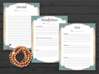 Three journal pages titled 'Journal', 'Mindfulness', and 'Love' on a wooden surface with a rosary.