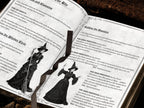 Open gothic ritual book showing illustrated pages about cleansing, circle casting, and calling the quarters, with vintage-style witch drawings, ornate borders, and a dark ribbon bookmark across the center.