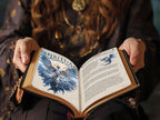 Person holding an open book titled 'Spiritual Empowerment' with illustrations and text.