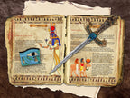 Two pages with images and text about the Goddess Hathor placed in a worn book of shadows.