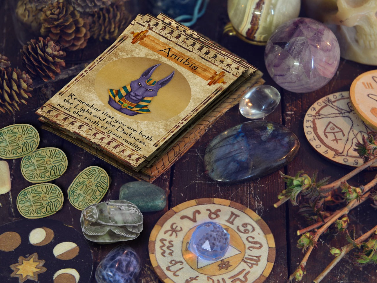 Egyptian Oracle cards are on a stacked deck upon an altar with crystals, pinecones, and Egyptian artifacts.