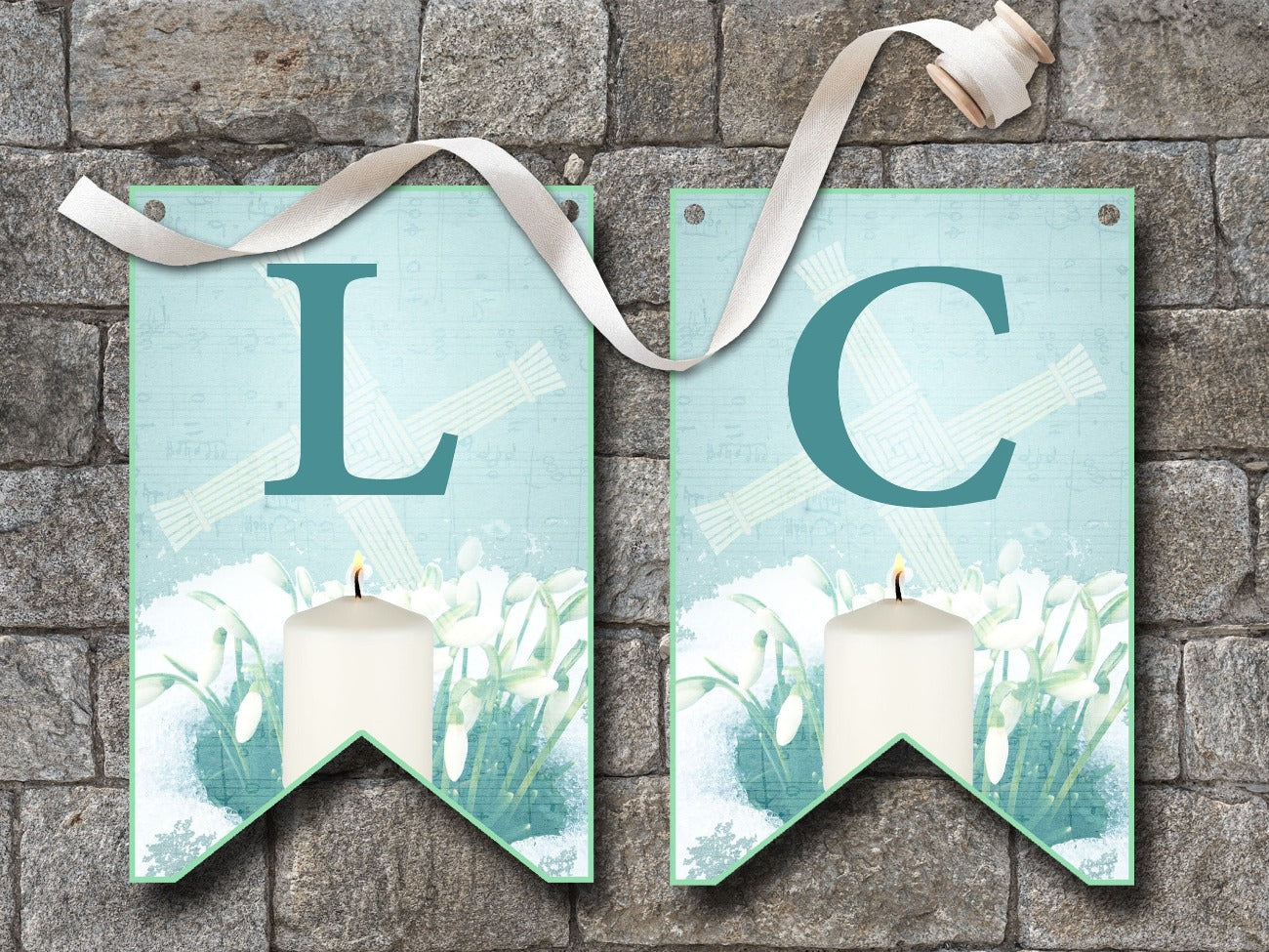 IMBOLC BANNER Bunting, Flags L and C, flags are pale blue with dark blue letters, each flag is imbellished with a Brigids Cross, snowdrops peeking through a layer of snow and a lit white candle - Morgana Magick Spell
