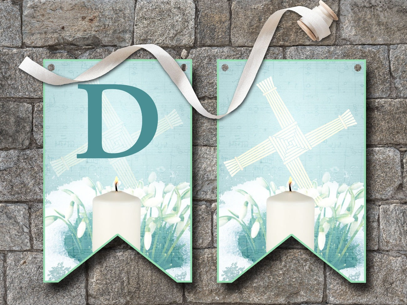 IMBOLC BANNER Bunting, Flags D and SPACER FLAG with no letter, flags are pale blue with dark blue letters, each flag is imbellished with a Brigids Cross, snowdrops peeking through a layer of snow and a lit white candle - Morgana Magick Spell