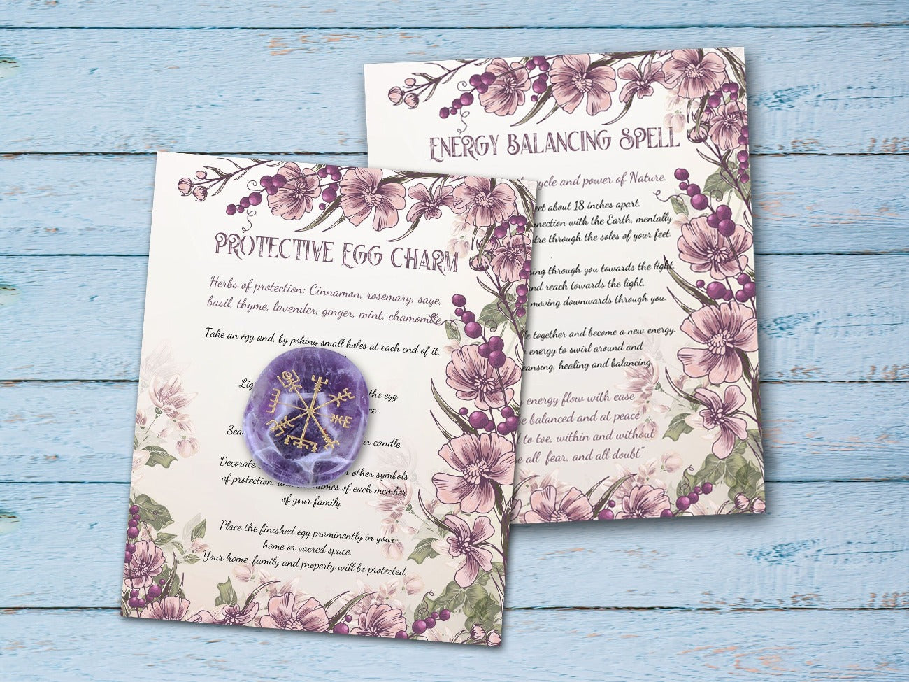 OSTARA SPELL CARDS, Protective Egg Charm and Energy Balancing Spell cards placed on a rustic blue wood background - Morgana Magick Spell